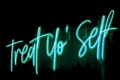 Treat Yo'self LED Neon Light Sign in turquoise, featuring script lettering viewed at an angle against a dark wall.