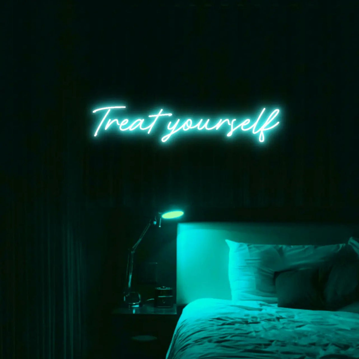 Treat Yourself LED Neon Light Sign in turquoise, featuring script lettering illuminated above a bed in a dark bedroom.
