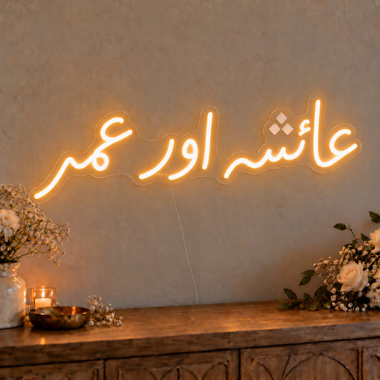 Urdu Couple Names Neon Sign on clear cut-to-shape acrylic, illuminated on a wall in a styled celebration setting; sample personalised wording shown